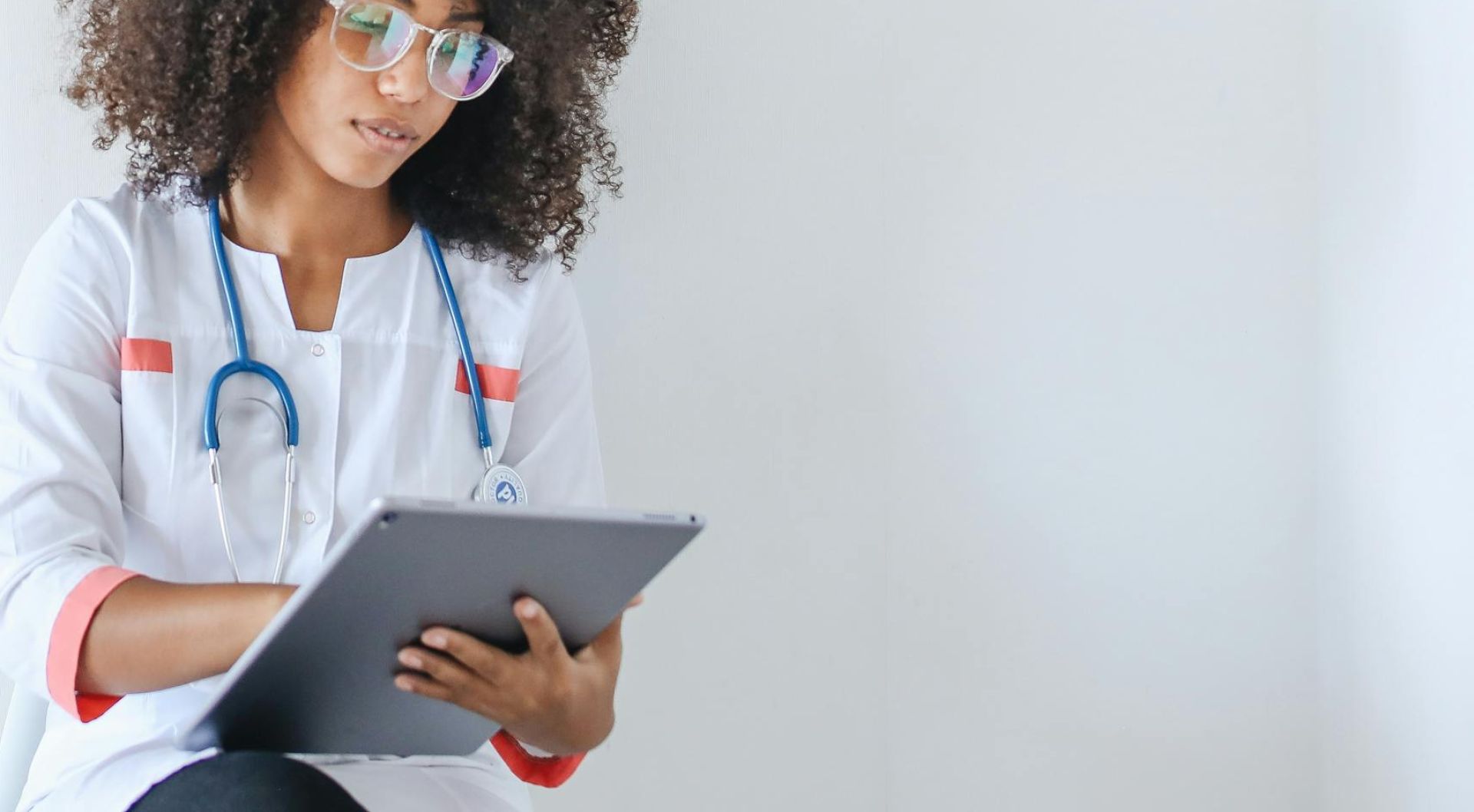 Woman in White Long Sleeve Coat Using a Tablet